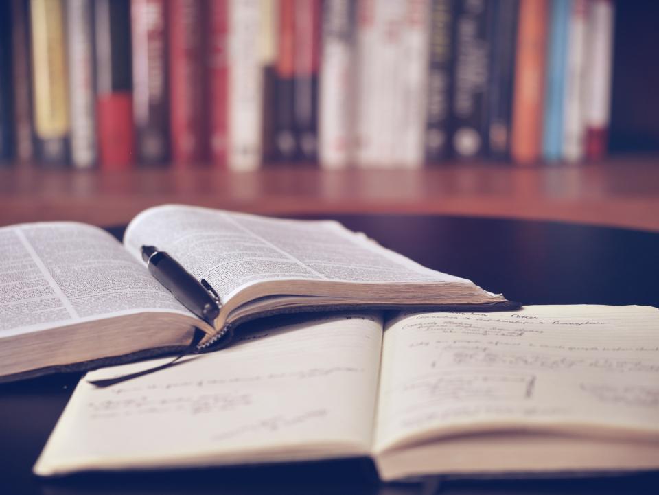 Libros y un cuaderno abiertos sobre una mesa